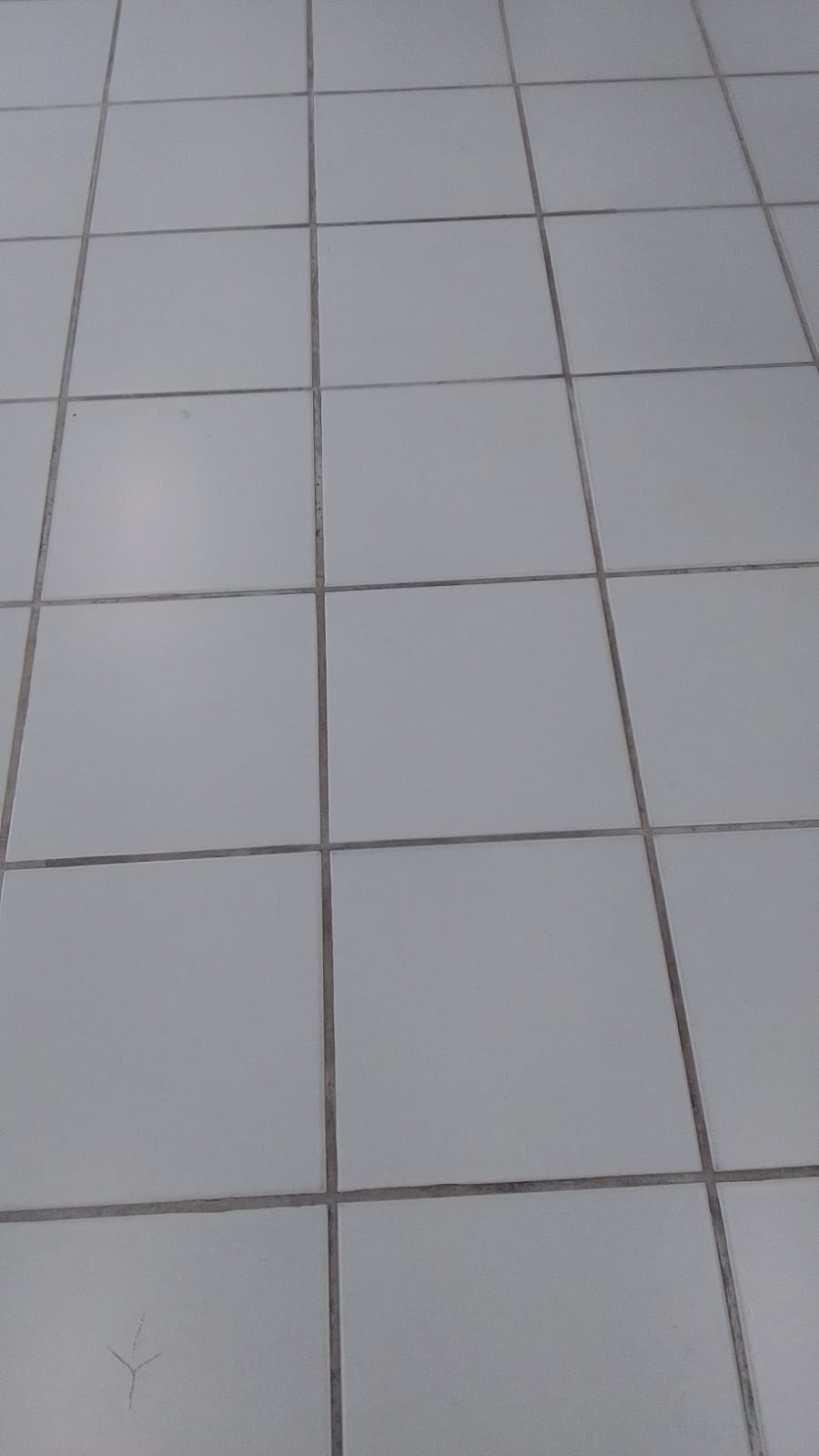 Piso cerâmico branco de área comum antes da limpeza