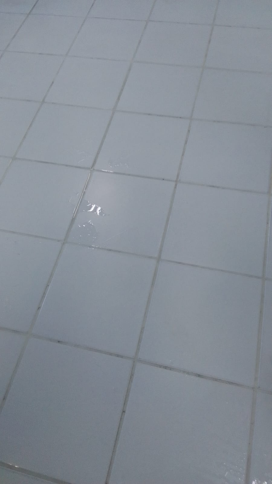 Piso cerâmico branco de área comum depois da limpeza, com brilho recuperado