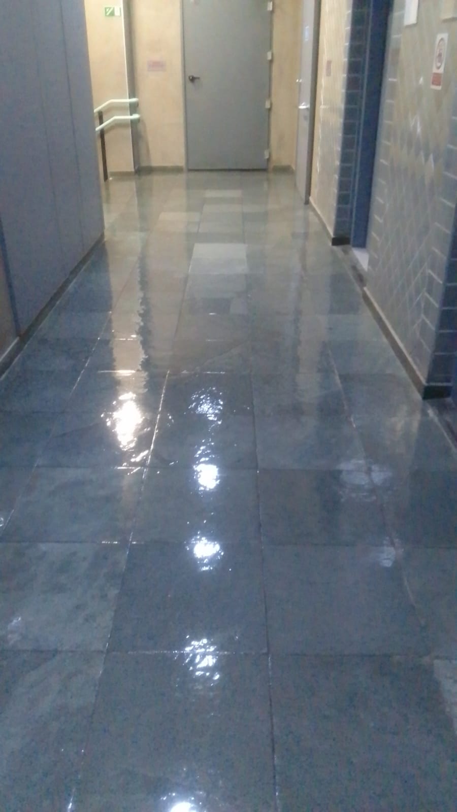 Corredor de prédio depois da limpeza, piso com brilho intenso